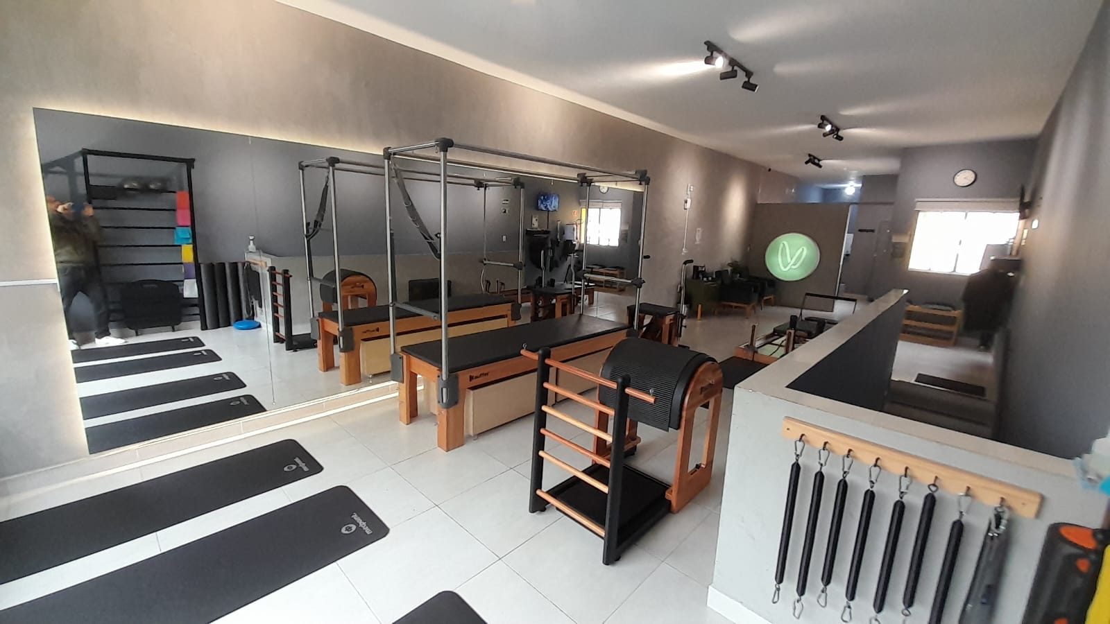 Sala principal do estúdio com cadillac, reformer e parede espelhada