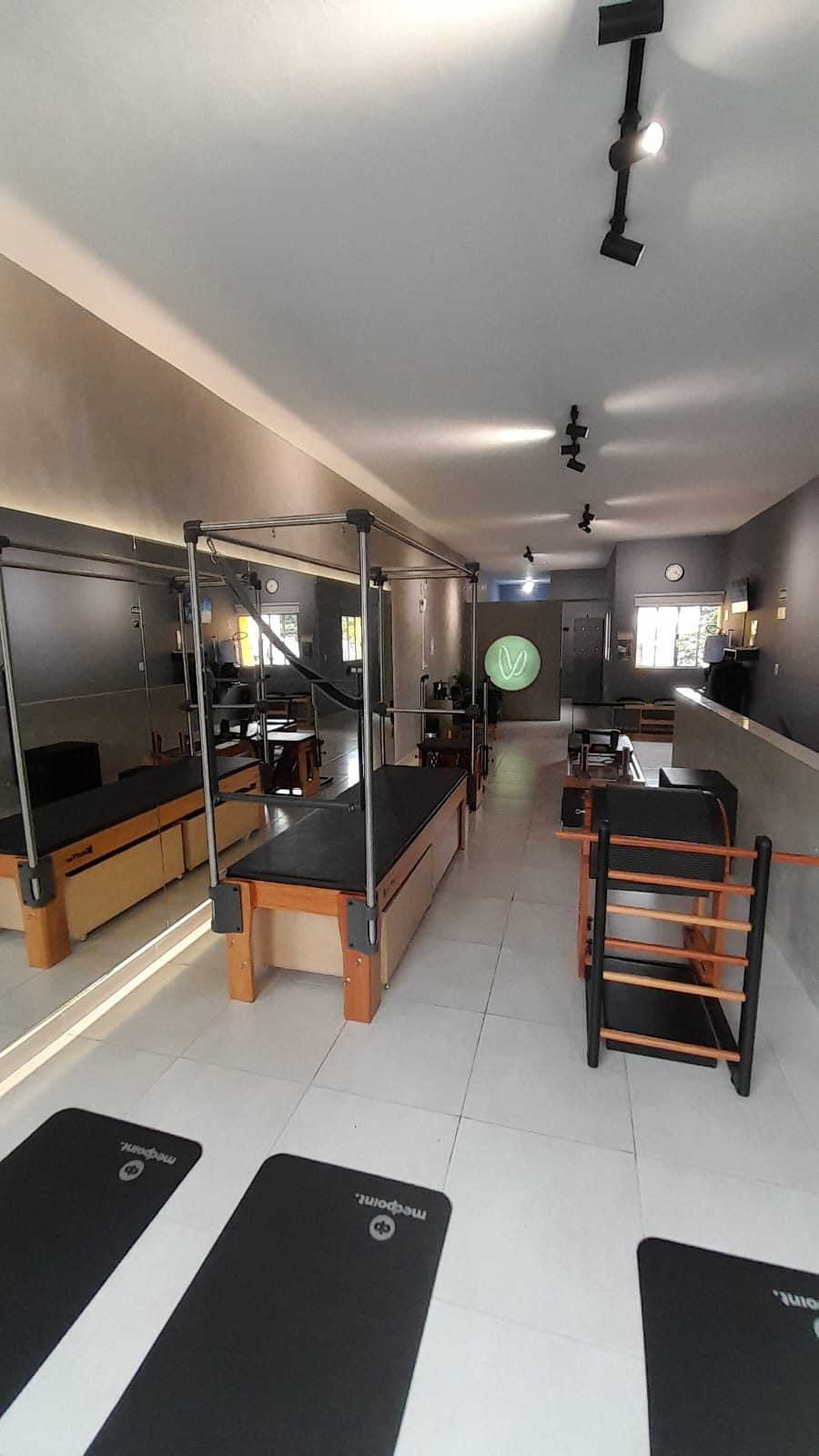 Estúdio Voll Pilates Aclimação, sala ampla com aparelhos completos e o V iluminado ao fundo